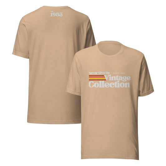 A tan unisex t-shirt with "Never Give Up Since 1983 Vintage Collection" graphic.