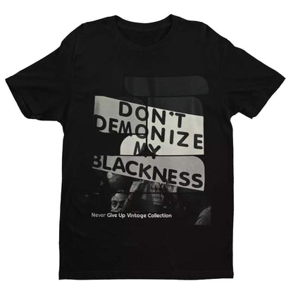 Black t-shirt with "Don't Demonize My Blackness" graphic.