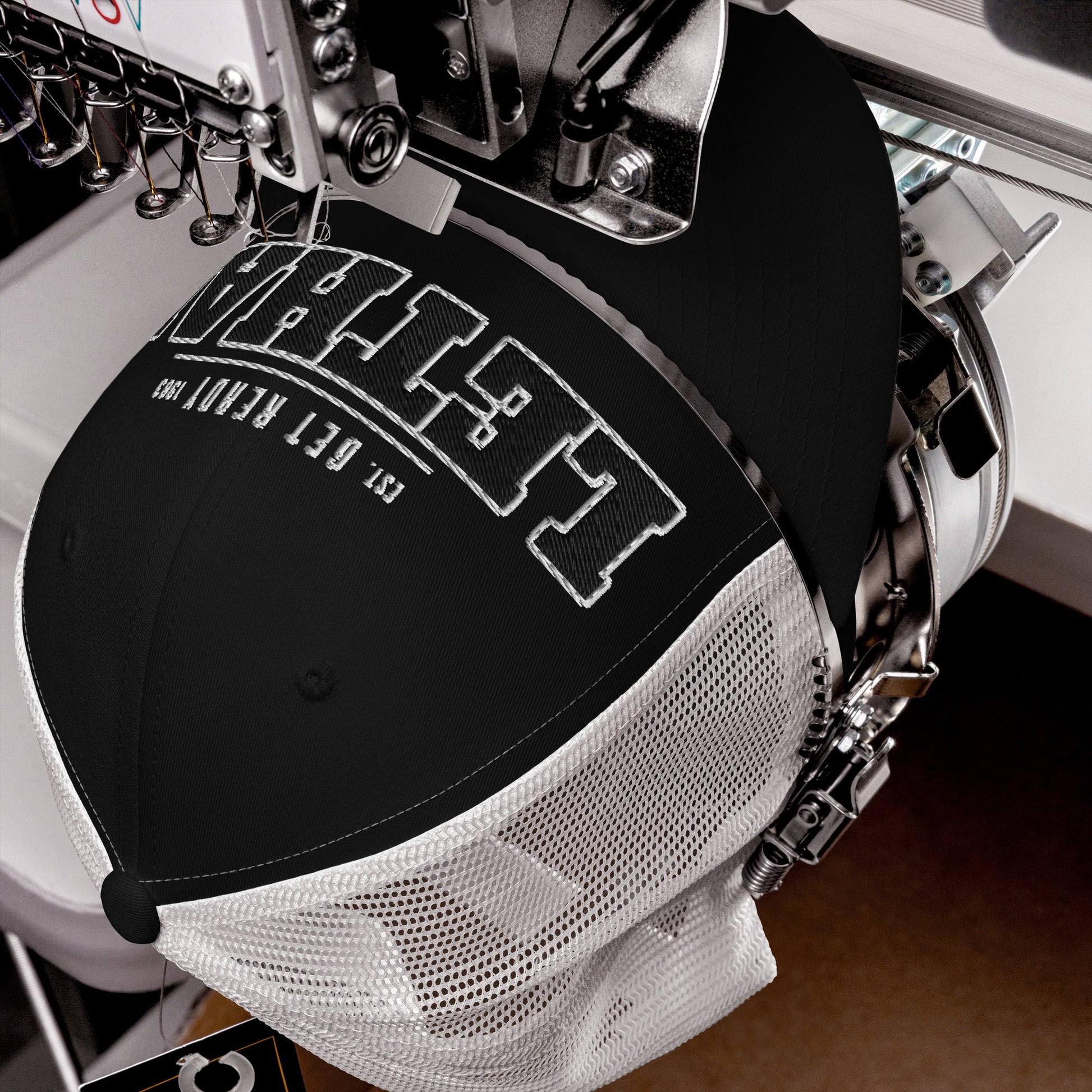 Black trucker cap with white embroidered text and mesh back.