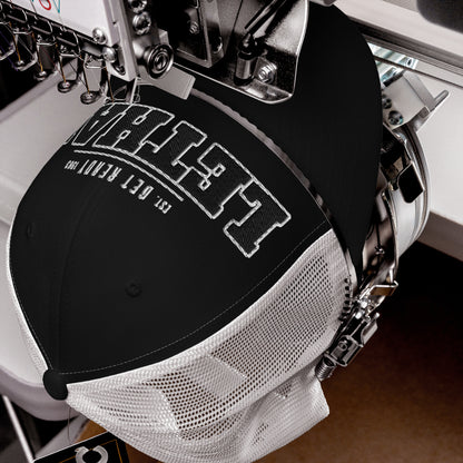 Black trucker cap with white embroidered text and mesh back.