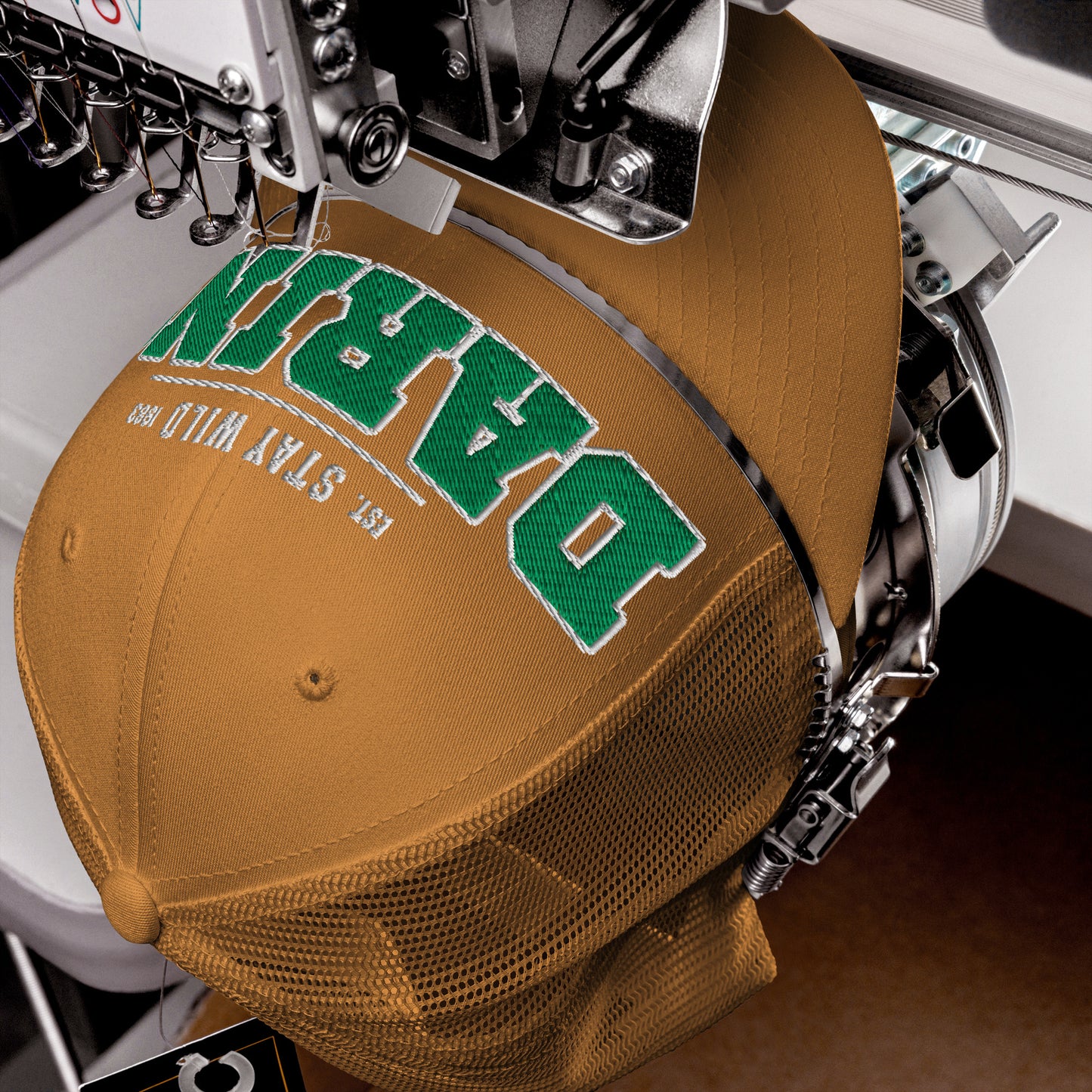 A brown trucker cap with green embroidered lettering and a mesh back.