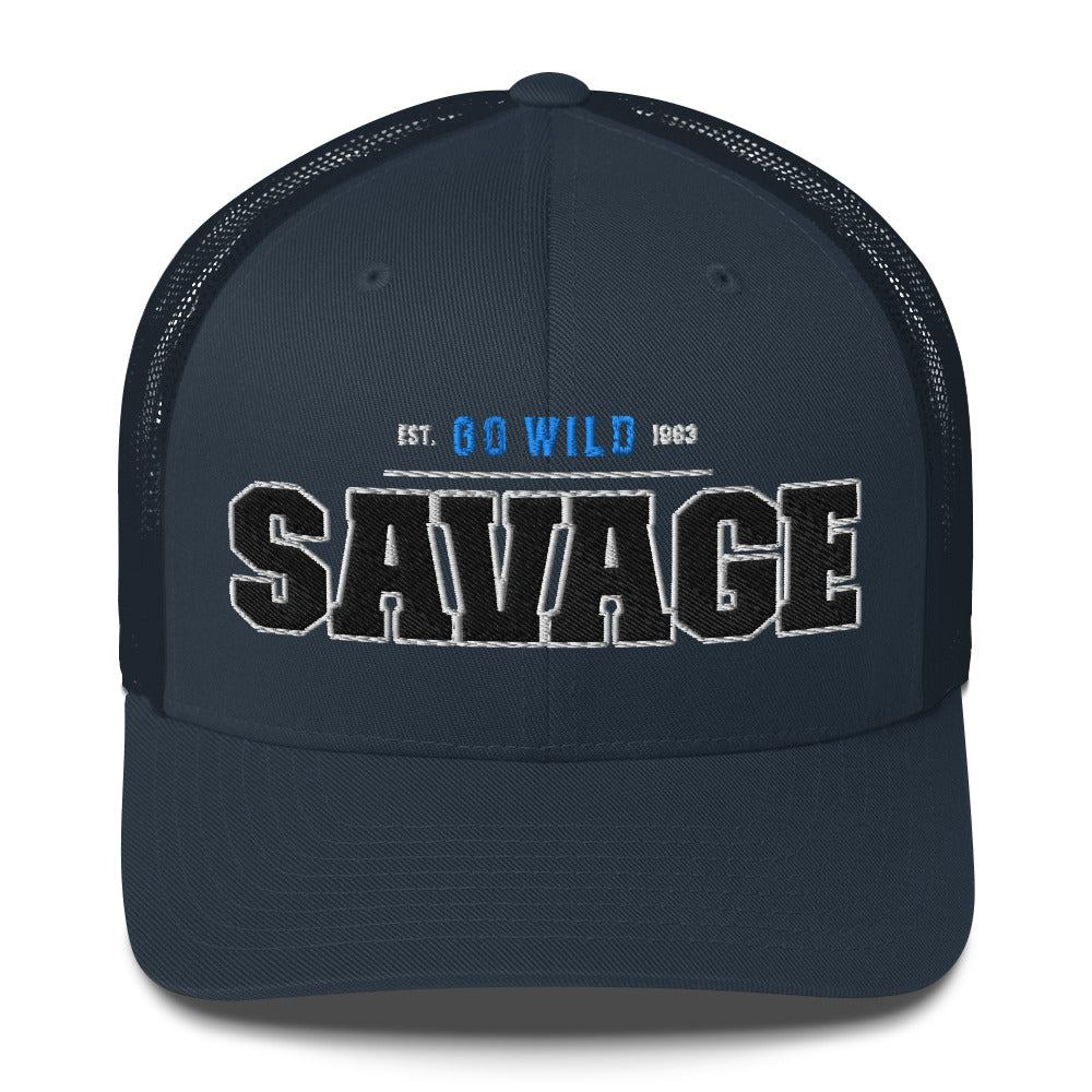 A navy blue trucker cap with "SAVAGE" and "EST. GO WILD 1963" embroidered on the front.