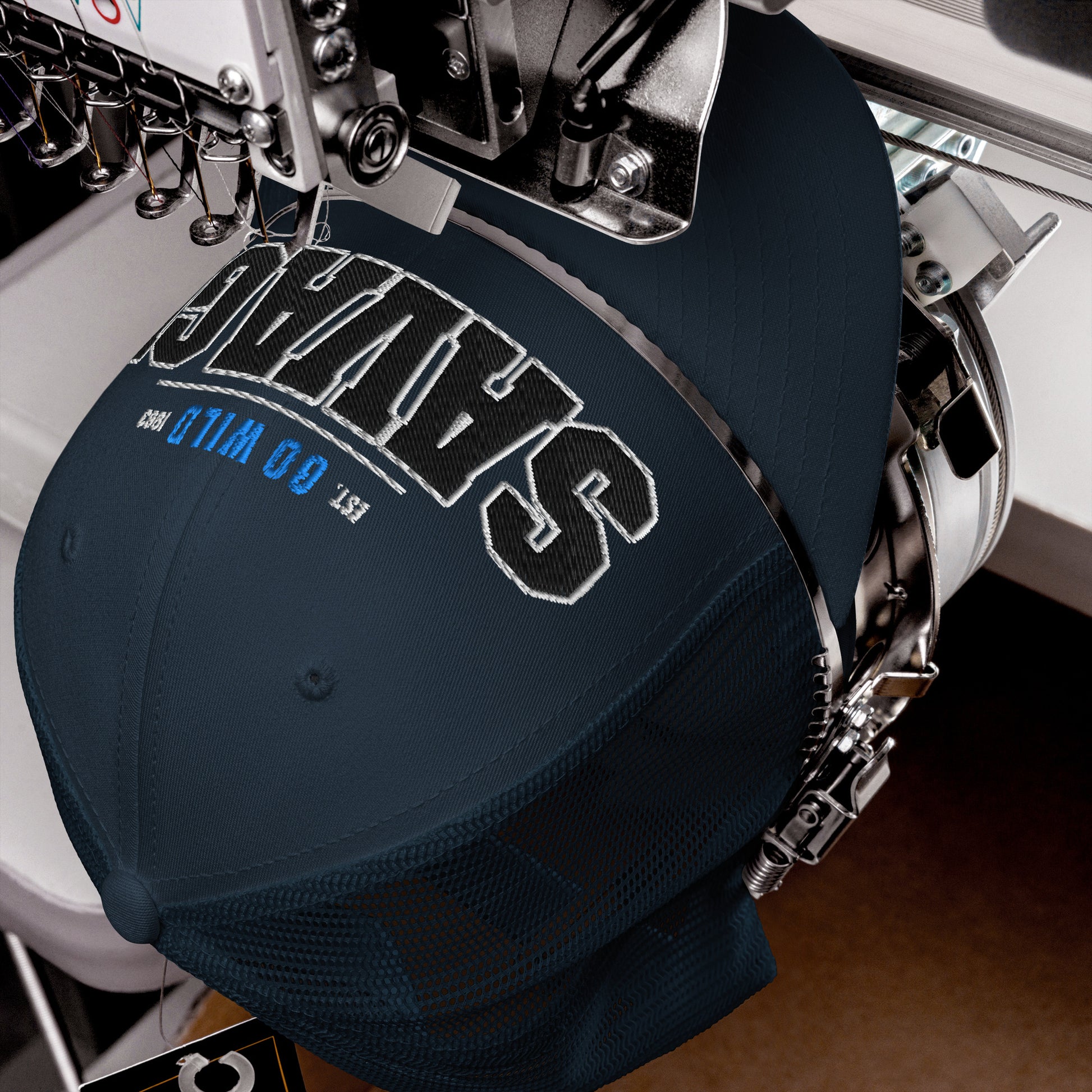 A navy blue trucker cap with white and black embroidered text.