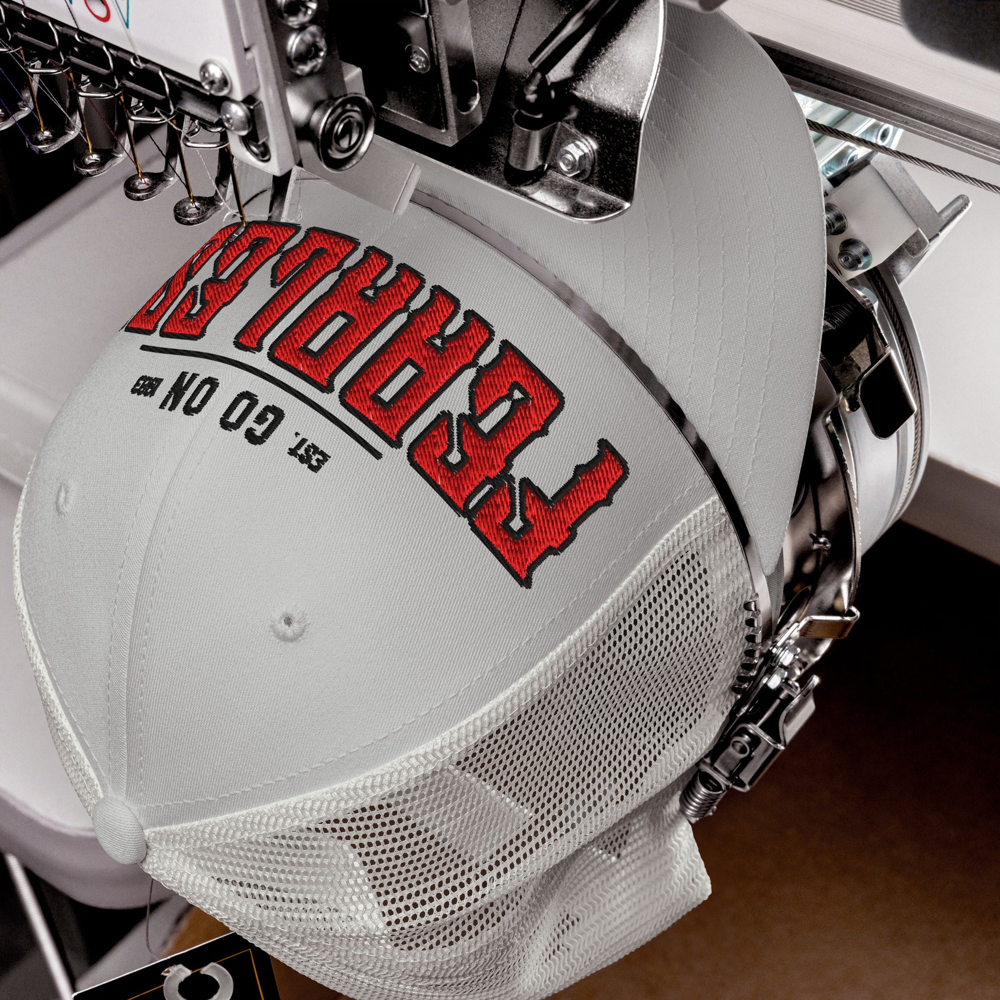 A light gray trucker cap with red embroidered text and a mesh back.