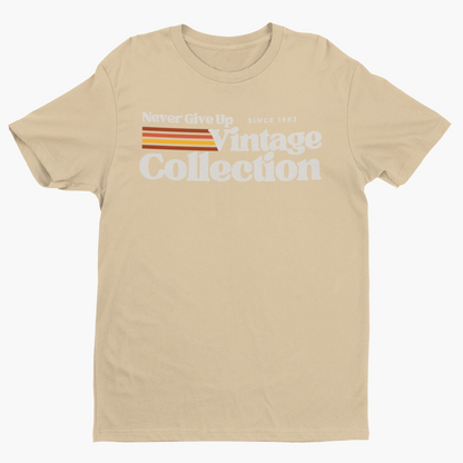A tan t-shirt with "Never Give Up Vintage Collection Since 1983" printed on it.