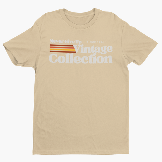 A tan t-shirt with "Never Give Up Vintage Collection Since 1983" printed on it.