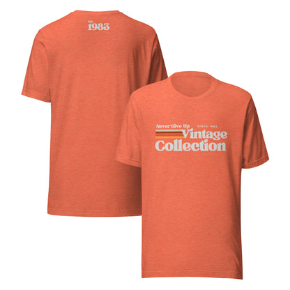 Orange unisex t-shirt with "Never Give Up Vintage Collection Since 1983" graphic.