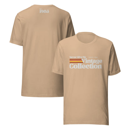 A tan unisex t-shirt with "Never Give Up Since 1983 Vintage Collection" graphic.